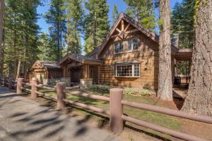 Holly House on the West Shore - New Hot Tub, Wood Fireplace, Near Skiing في تاهو سيتي: منزل خشبي في الغابة مع سياج