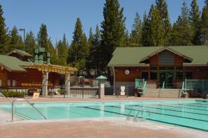 a large swimming pool in front of a lodge at Kokanee at Tahoe Donner - Charming 3 BR - Pool Table - Fireplace - Amenity Access! in Truckee