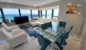Luxury Beach Resort - HORA RENTALS في ميامي بيتش: غرفة طعام مع طاولة وكراسي زجاجية