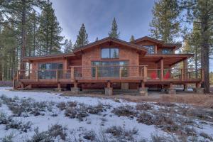 a log cabin in the woods in the snow at Meek Court at Grays Crossing - Modern Luxury with Private Hot Tub in Truckee