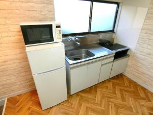 a small kitchen with a sink and a microwave at futaba heights - Vacation STAY 15532 in Tokyo