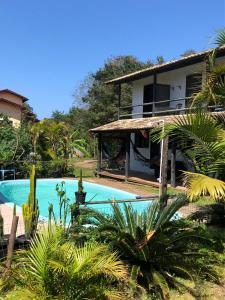 a house with a swimming pool in front of a house at Solar da Suzi in Praia do Rosa