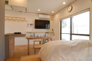 1 dormitorio con 1 cama, escritorio y TV en futaba heights - Vacation STAY 15415, en Tokio