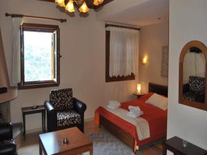 um quarto de hotel com uma cama e uma cadeira em Guesthouse Kallisti em Anilio Pelion
