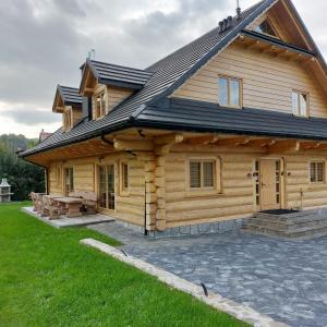 una cabaña de madera con techo de gambrel en Apartamenty Złoty Stok, en Szczyrk