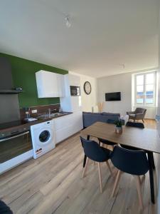 a kitchen and living room with a table and chairs at Le Duplex Tout Confort in Bressuire