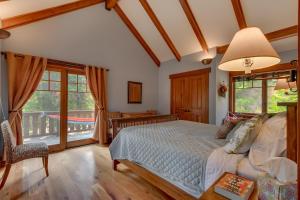 a bedroom with a bed and a balcony at Mountain Escape at North Shore - Upscale 4BR Easy Walk to Lake & Private Hot Tub! in Carnelian Bay