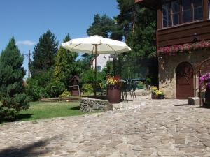 a patio with an umbrella next to a building at Willa na Bani - apartamenty i pokoje in Rabka
