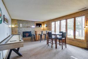 ブレーナードにあるWaterfront Brainerd Cabin with Rice Lake Access!のテーブルと椅子、暖炉が備わる客室です。