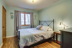 Schlafzimmer mit einem Bett und einem Fenster in der Unterkunft Waterfront Brainerd Cabin with Rice Lake Access! in Brainerd