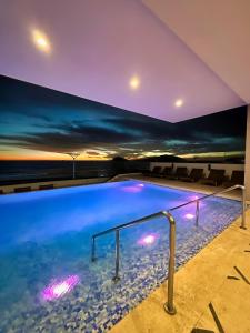 una piscina en una casa con una pintura en la pared en Altomare Seaview en Mazatlán