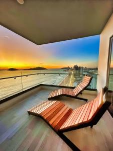 two benches on a balcony with a view of the ocean at Altomare Seaview in Mazatlán