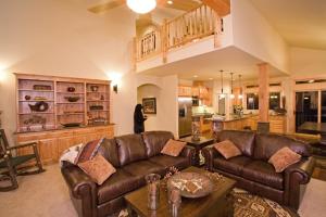 a living room with a leather couch and a kitchen at Olive Branch - Private Hot Tub, Media Room, Pet-Friendly, Near Northstar! in Carnelian Bay