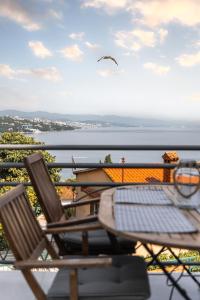 een tafel en stoelen op een balkon met uitzicht op het water bij New cosy apartments with private parking in Opatija