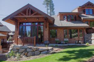 a log home with a porch and a stone wall at Mountainside - Luxury Northstar Ski-in Ski-Out - Swimming Pool and Gym! in Truckee