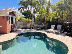 a swimming pool in a yard with chairs and a table at 5 Bedrooms with pool near beach in Clearwater Beach