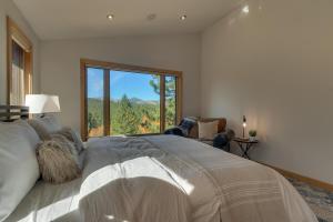 um quarto com uma cama grande e uma janela grande em Pinnacle Views at Tahoe Donner - 4BR, Hot Tub em Truckee