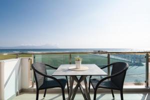 Vrahakia beach في سارتي: طاولة وكراسي على شرفة مطلة على المحيط