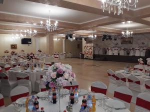 雅西的住宿－Pensiunea Escape，宴会厅配有白色的桌椅和鲜花