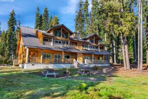 a log home with picnic tables in front of it at Shelter Cove Resort & Marina in Odell Lake