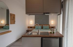 - une cuisine avec évier et un lit dans une chambre dans l'établissement Vrahakia beach, à Sarti