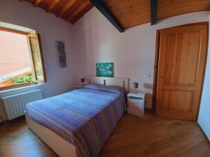 Schlafzimmer mit einem Bett, einem Fenster und einer Tür in der Unterkunft Casina Iris - Reggello in Reggello