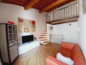 a living room with a couch and a tv and stairs at Casina Iris - Reggello in Reggello