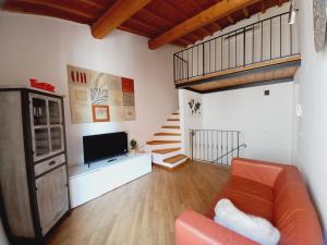 - un salon avec un canapé, une télévision et des escaliers dans l'établissement Casina Iris - Reggello, à Reggello