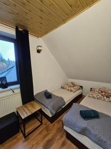 three beds in a room with a window at Zawoja Nad Koroną z jacuzzi in Zawoja