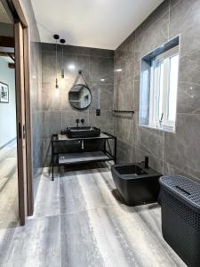 a bathroom with a black tub and a sink at Valletta Stylish 2 Beds Flat in Valletta