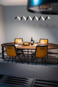 a dining room table with chairs and a bottle of wine at Valletta Stylish 2 Beds Flat in Valletta