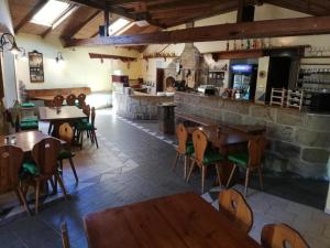 um restaurante com mesas e cadeiras de madeira e um bar em ALMI - penzion - pizzerie em Staré Splavy