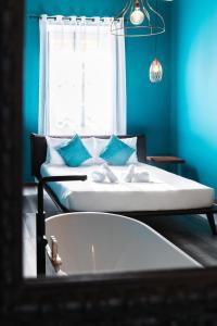 a blue room with two beds and a window at Valletta Stylish 2 Beds Flat in Valletta