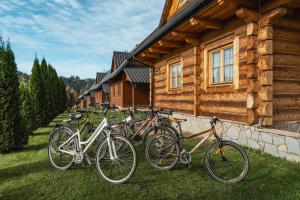eine Gruppe von Fahrrädern, die außerhalb eines Blockhauses geparkt werden in der Unterkunft Domki u Adasia in Krośnica