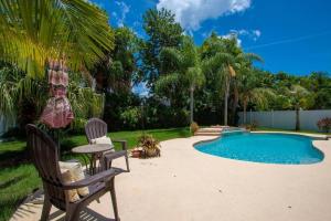 a backyard with a pool and two chairs and a table at Beach and Pool, what more do you need? in Clearwater Beach