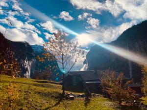 a house in a field with the sun in the sky at Chalet Bärgstäger in Lauterbrunnen