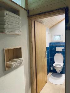a bathroom with a toilet and a door with towels at Chalet Bärgstäger in Lauterbrunnen
