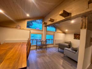 a living room with a wooden floor and windows at Chalet Bärgstäger in Lauterbrunnen