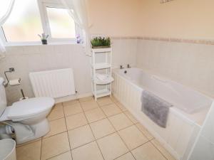 a bathroom with a tub and a toilet and a sink at Coneyville in Derry Londonderry +23 photos