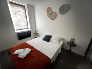 een slaapkamer met een bed met twee handdoeken erop bij Le Grand Huit Un Séjour à Part in Saint-Julien-lès-Metz