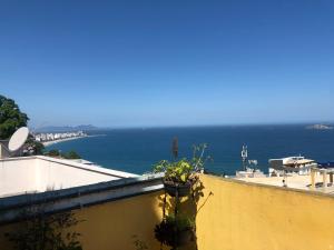 a plant on the side of a wall with the ocean at Hostel Alzira House Vidigal in Rio de Janeiro