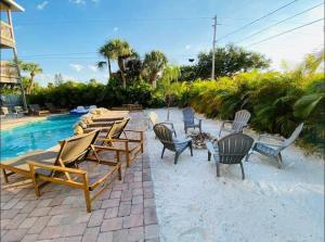 un gruppo di sedie a sdraio accanto alla piscina di 6 Bedrooms 4 Bath with sand and heated pool a Clearwater Beach