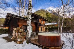 a log cabin with a hot tub in the snow at Mazot les Tines in Chamonix-Mont-Blanc