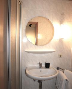 a bathroom with a sink and a mirror at Haus Heimatfrieden Mittenwald in Mittenwald +13 photos