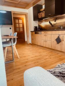 uma cozinha com armários de madeira e uma mesa com mesa; em Haus Heimatfrieden Mittenwald em Mittenwald