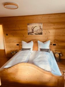 um quarto com uma cama grande e paredes de madeira em Haus Heimatfrieden Mittenwald em Mittenwald