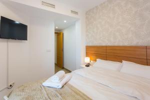 1 dormitorio con 1 cama con 2 toallas en Piso familiar cerca del centro, AC y Wifi gratis (PA), en Valencia