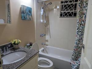 een badkamer met een wastafel, een toilet en een douche bij La Palmera in Saint Annʼs Bay