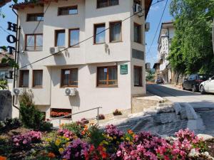 un edificio bianco con dei fiori di fronte di Hotel Herc Sarajevo a Sarajevo