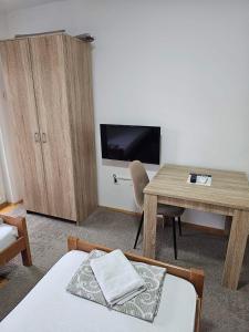 - un salon avec une table et une télévision dans l'établissement Akvarius, à Niš
